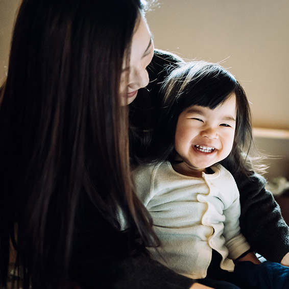 母親の膝の上に座る笑顔の子供